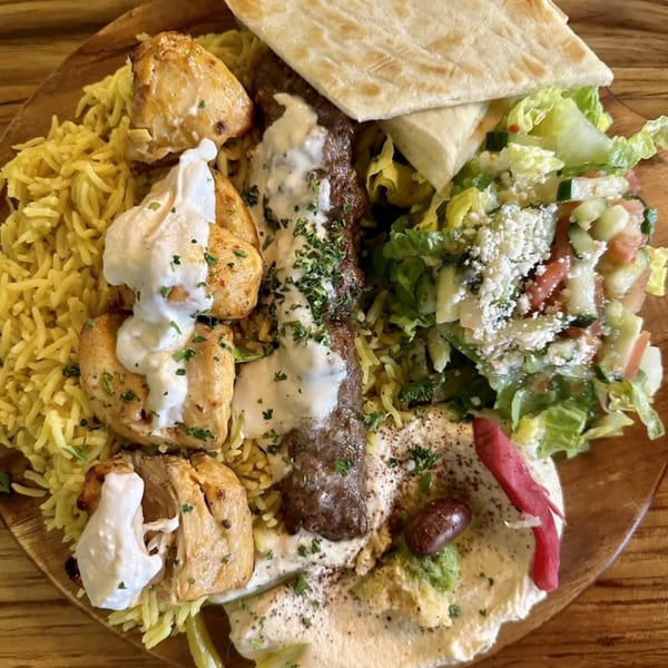 Shawarma Time's Mediterranean platter with chicken, rice, salad, hummus, and pita bread.