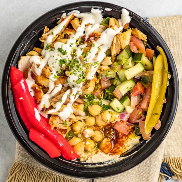 Shawarma Time bowl with chicken, hummus, chickpeas, salad, red peppers, and a yellow pepper.